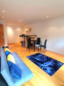 uma sala de estar com um sofá azul e uma mesa em Long-term Retreat! Family & Business - 5 Beds City Apt & Parking - 中国搬迁 em Leeds