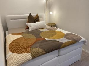 Un dormitorio con una cama con una manta. en Hotel Villa Vital Munster, en Munster im Heidekreis