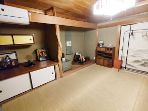 una sala de estar con una habitación grande con suelo de madera. en Fukubatake B&B, en Yoshino