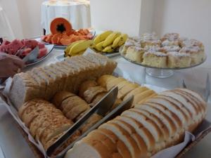 a table filled with different types of bread and desserts at Petit Praia Hotel in Florianópolis