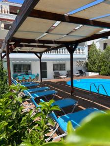 een rij blauwe ligstoelen naast een zwembad bij Villa Vave in Nea Iraklia