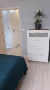 a bedroom with a bed and a dresser with a plant on it at Apartament Zalesie z tarasem in Lubin