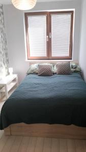 a large bed in a bedroom with a window at Apartament Zalesie z tarasem in Lubin