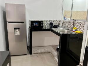 a kitchen with a sink and a refrigerator at DEPARTAMENTO EN CIPRESES in Urbanizacion Buenos Aires