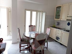 a kitchen with a table and chairs in a room at Sardinia ovest in Oristano