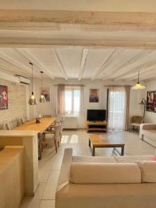 Koumaros Villas في أغيا باراسكيفي: غرفة معيشة مع كنب وطاولة طعام
