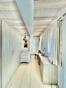 アギア・パラスカヴィにあるKoumaros Villasの白い部屋(ベッド1台、テーブル付)