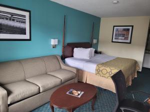 a hotel room with a bed and a couch at Baymont Inn & Suites by Wyndham Florence in Florence