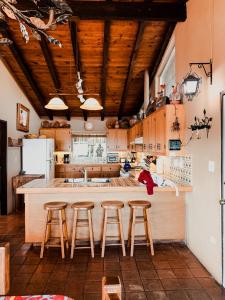 una cocina con armarios de madera y una barra con taburetes en Su Casa, en Ensenada