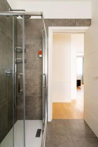 La salle de bains est pourvue d'une douche avec une porte en verre. dans l'établissement Kaizen House - Bilocale De Angeli, à Milan