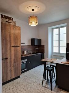 a kitchen with a counter and a table with stools at Appartement La Couronne Sarlat-La-Canéda in Sarlat-la-Canéda