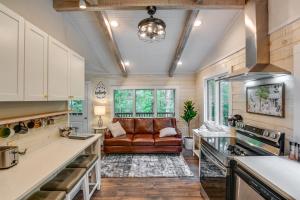 a kitchen and living room with a leather couch at Cozy Tennessee Retreat with Patio and Charcoal Grill! in Linden