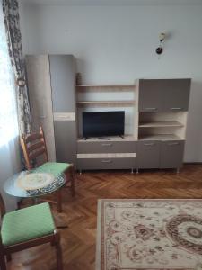 a living room with a tv and a table and chairs at Casa Rebeca in Orşova