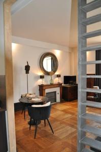 a living room with a table and a mirror at Appartement La Couronne Sarlat-La-Canéda in Sarlat-la-Canéda