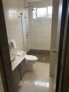 a bathroom with a toilet and a sink and a shower at Lindo apartamento cerca de Centro Comercial unico in Barranquilla