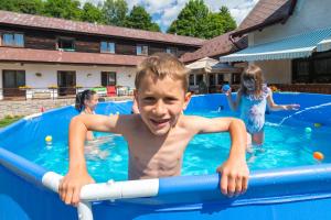 a young boy in a swimming pool at Penzion Vápenka in Horní Maršov