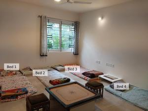 Cette chambre dispose de 4 lits et d'une fenêtre. dans l'établissement Resort Style Luxury Villa on Sarjapur Road, à Bangalore