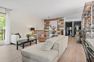 a living room with a white couch and a table at Le Panaché-Chalet à louer Stoneham in Stoneham