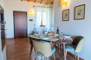 comedor con mesa y sillas en Anemoni Home nel Borgo di Montegridolfo by Yohome, en Montegridolfo