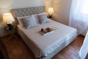 Un dormitorio con una cama con una bandeja de comida. en Anemoni Home nel Borgo di Montegridolfo by Yohome, en Montegridolfo