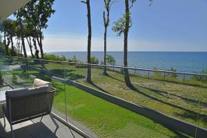 un balcón con un banco y vistas al océano en Rewal HEVENIA Premium Baltic Apartment with SPA access, en Rewal