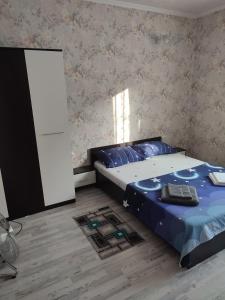 a bedroom with a bed with blue sheets and a mirror at Casa Rebeca in Orşova