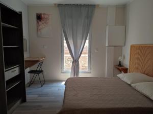 Schlafzimmer mit einem Bett und einem Fenster in der Unterkunft Location appartement T3 à Sète in Sète