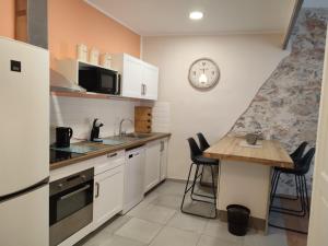 eine Küche mit einem Tisch und einer Uhr an der Wand in der Unterkunft Location appartement T3 à Sète in Sète
