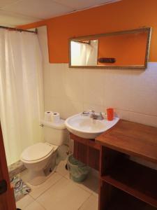 y baño con aseo, lavabo y espejo. en Surfari Bocas en Bocas del Toro