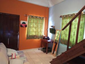 a living room with a staircase and green curtains at Surfari Bocas in Bocas Town