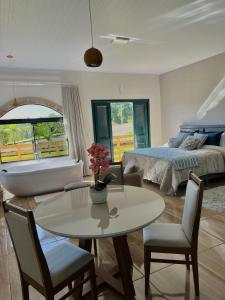 a living room with a bed and a table and chairs at Pousada Di Venezia - Hotel Fazenda in Nova Veneza