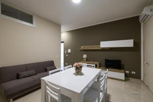 a living room with a white table and a couch at Casa Vacanza Egan Scanzano J in Scanzano