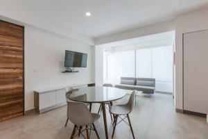 a living room with a table and chairs and a couch at Moderno y amplio estudio en el centro de Playa in Playa del Carmen
