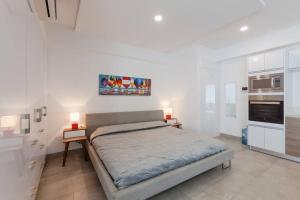 a bedroom with a large bed and a kitchen at Moderno y amplio estudio en el centro de Playa in Playa del Carmen