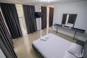 a bedroom with a bed and a desk and windows at Cazare Dumbrava in Eforie Sud