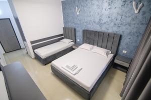 a small room with two beds and a chair at Cazare Dumbrava in Eforie Sud