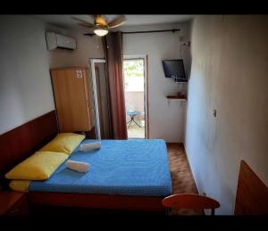 um pequeno quarto com uma cama azul e uma janela em Studio Manora Sucuraj em Sućuraj