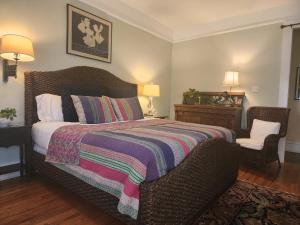 1 dormitorio con 1 cama con manta y silla en Rosemont B&B Cottages, en Little Rock