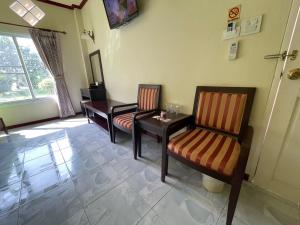a living room with two chairs and a table at ธนวรรณรีสอร์ท - Thanawan Resort in Ban Phra Trong