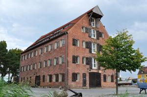 a large red brick building with a tree in front of it at Der Speicher in Wolgast