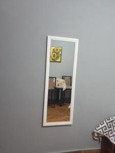 a mirror hanging on a white wall with a room at ESTUDIO EL ANGEL. in Santa Cruz Huatulco