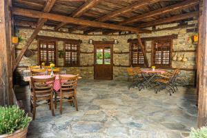 a patio with tables and chairs in a stone building at Lavanda Restaurant with Rooms in Kovačevica