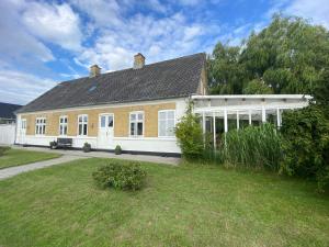 a large house with a large yard in front of it at Lindebjerggårds Bed and Breakfast in Melby