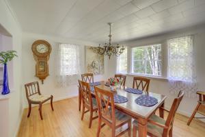 a dining room with a table and chairs and a clock at Calumet Township Cottage about 1 Mi to Lake Superior in Calumet
