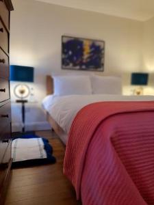 Un dormitorio con una cama con una manta roja. en Berlin Wall Apartment at The Residence Bantry en Bantry