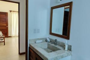 ein Badezimmer mit Waschbecken und Spiegel in der Unterkunft Apartment Tortugas - rooms with AC and great pool at 5 min from Carrizalillo beach and Benito Juarez Bulevard in Puerto Escondido + 17 Fotos