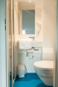 a bathroom with a toilet and a sink and a mirror at SmartAppart Troyes in Troyes