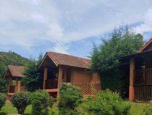 a house with a fence and trees in front of it at Pousada Recanto da Vitória in Gonçalves