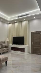 sala de estar con TV de pantalla plana y chimenea en The calm Zone, 