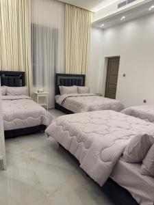 two beds in a room with white walls at The calm Zone 